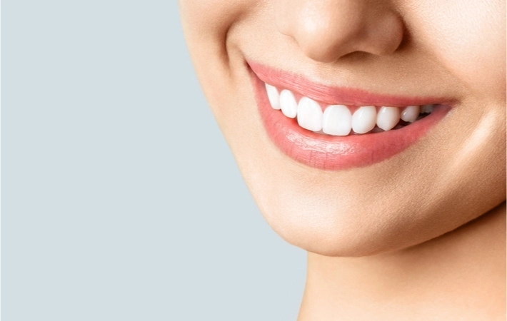 Image showing the bottom half of a woman's face smiling and showing a beautiful set of teeth.