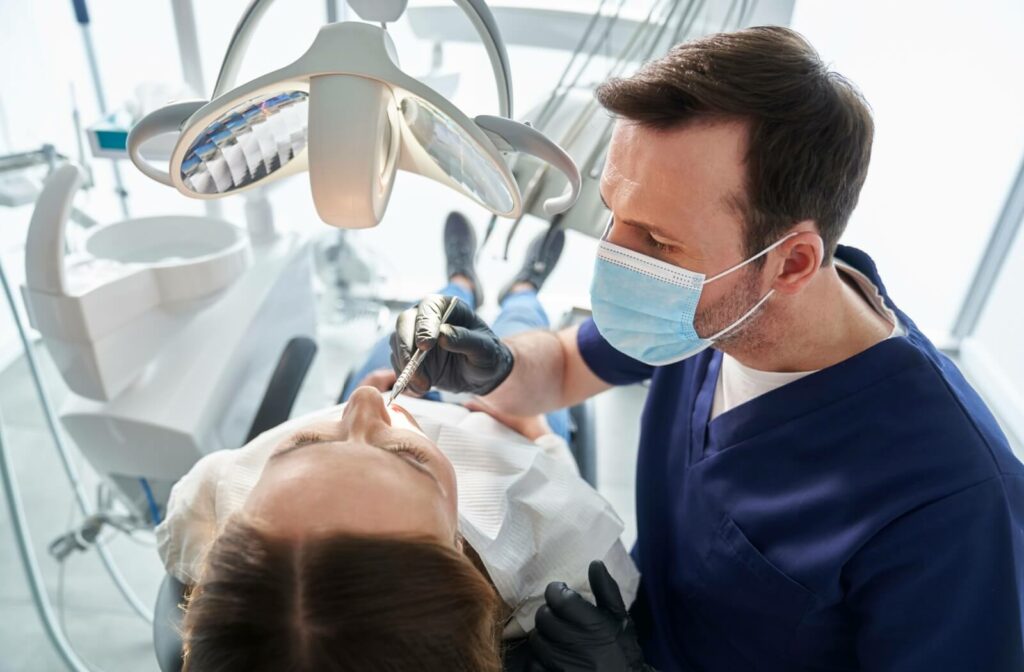 Dentist performing an examination on a patient, inspecting the teeth.