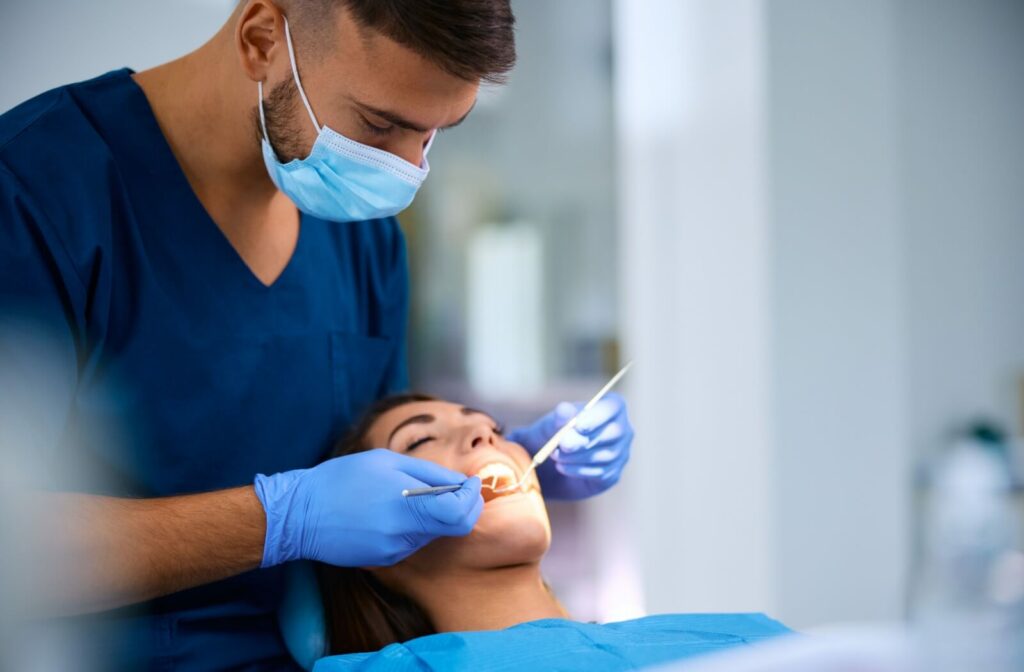 Patient laying back on a dental chair getting a recall exam from a hygienist