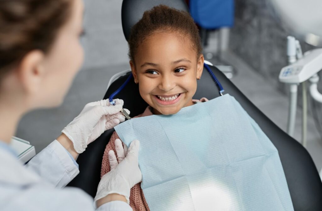 A young child smiling in a dental chair